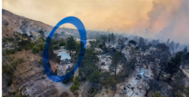 Aerial view of a fire-ravaged hillside in Altadena after the Eaton Fire, with blackened trees and ash-covered foundations surrounding a single intact, light-colored house still standing amid widespread destruction; smoke hangs in the sky.